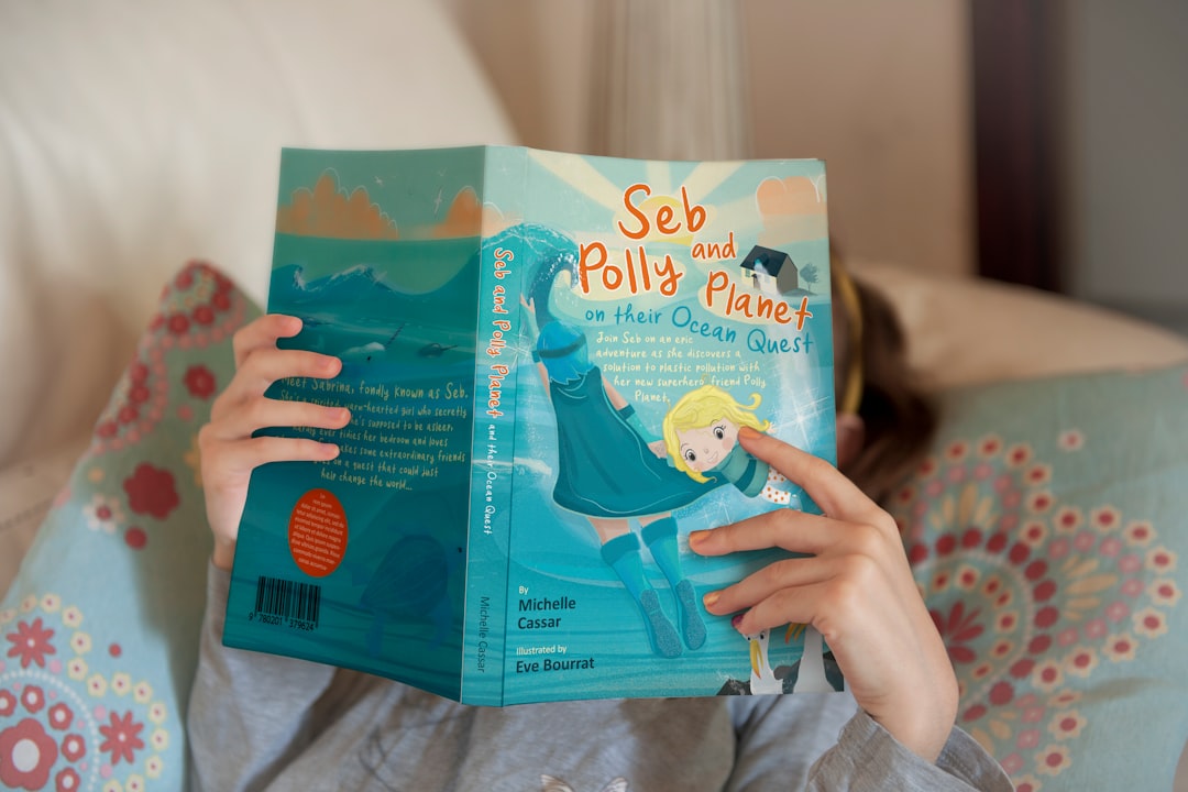 Kind liest ein Buch auf dem Sofa